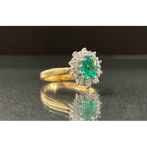 285 - An Emerald and diamond cluster ring, central oval emerald, 0.55ct, surrounded by ten round brilliant... 