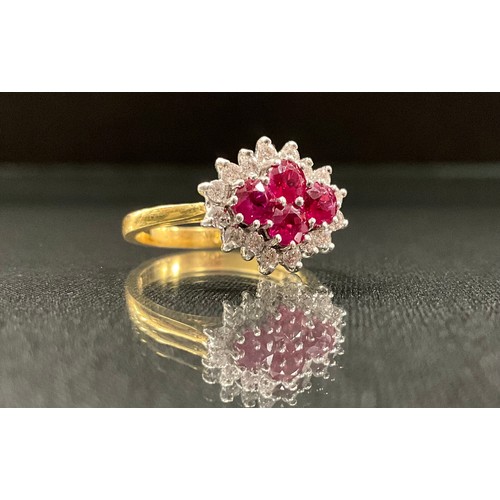 243 - A ruby and diamond cluster ring, with four pinky red round cut diamonds, surrounded by sixteen round... 