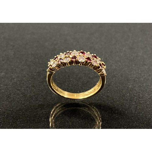 191 - A diamond and ruby ring, set with two rows of alternating round brilliant cut diamonds and round cut... 