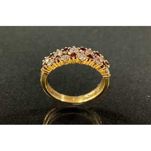 191 - A diamond and ruby ring, set with two rows of alternating round brilliant cut diamonds and round cut... 