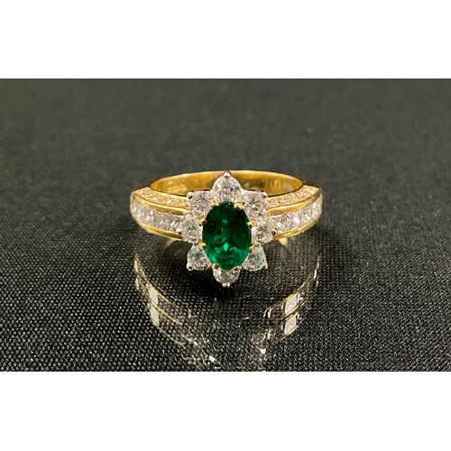 286 - An emerald and diamond cluster ring, central oval vibrant green emerald, 0.75ct, surrounded by eight... 