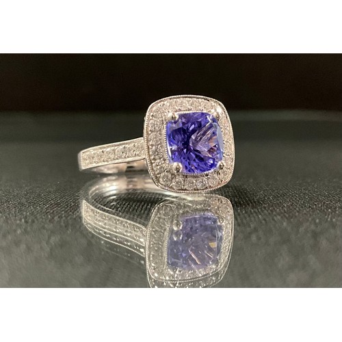 253 - A tanzanite and diamond ring, central cushion cut tanzanite approx 1.66ct, surrounded by twenty roun... 