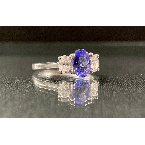 254 - A tanzanite and diamond ring, central oval tanzanite approx 1.06ct, between oval cut diamonds, total... 