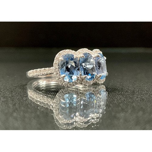 271 - An aquamarine and diamond ring, three oval strong blue aquamarines, total weight, 2.14ct, surrounded... 