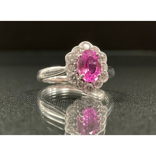 235 - A pink sapphire and diamond cluster ring, oval pink sapphire, 0.98ct surrounded by twelve round bril... 