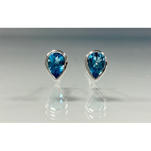 223 - A pair of 9ct white gold pear cut blue topaz stud earrings, 1g gross.