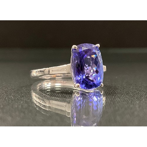 255 - A tanzanite and diamond ring, emerald cut tanzanite 3.72ct, above baguette diamond set shoulders, to... 