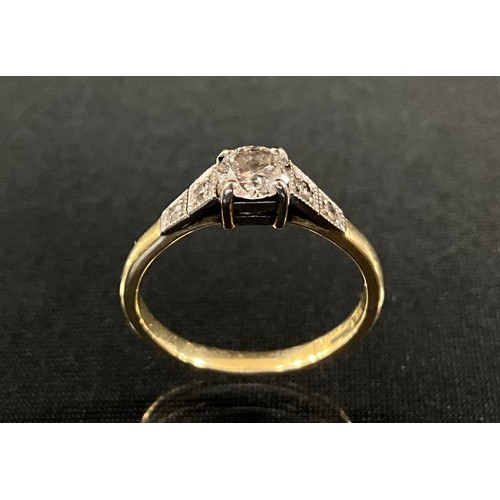 202 - A diamond solitaire ring, round brilliant cut diamond between two stone diamond accented shoulders, ... 