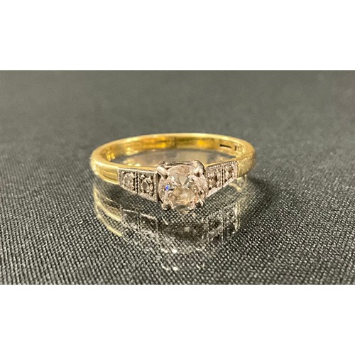 202 - A diamond solitaire ring, round brilliant cut diamond between two stone diamond accented shoulders, ... 