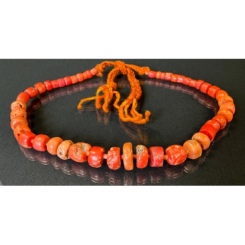 182 - A coral bead necklace, composed of over fifty graduated irregular and barrel shaped beads, many with... 