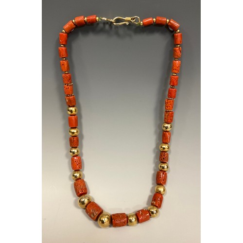 257 - A tubular coral bead and yellow metal ball necklace, composed of thirty one graduated coral beads, e... 