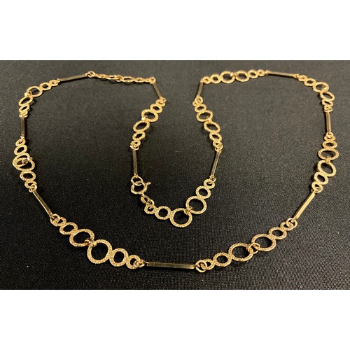 163 - A 9ct gold fancy loop and bar link necklace, with textured stepped graduated triple ring and alterna... 