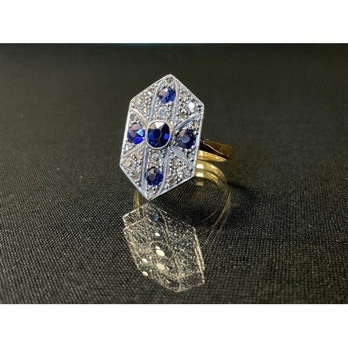 272 - An Art Deco sapphire and diamond cluster ring, the elongated hexagonal shield plaque set with five b... 