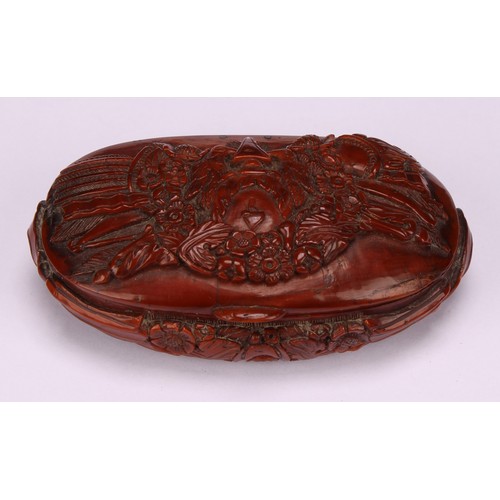 643 - Snuff - a 19th century oval coquilla nut snuff box, carved with military trophies and stylised leave... 