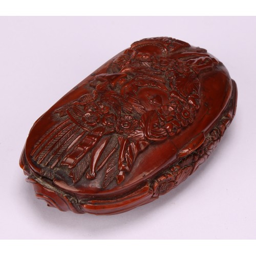 643 - Snuff - a 19th century oval coquilla nut snuff box, carved with military trophies and stylised leave... 