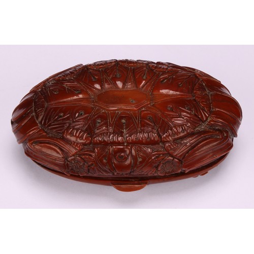 643 - Snuff - a 19th century oval coquilla nut snuff box, carved with military trophies and stylised leave... 