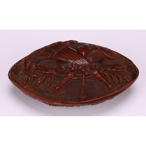 631 - Snuff - a 19th century navette shaped coquilla nut snuff box, carved with musical trophies and cupid... 