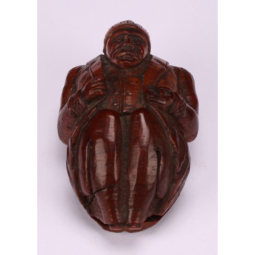 636 - Snuff - a 19th century novelty coquilla nut snuff box, carved as a French infantryman dressed in uni... 