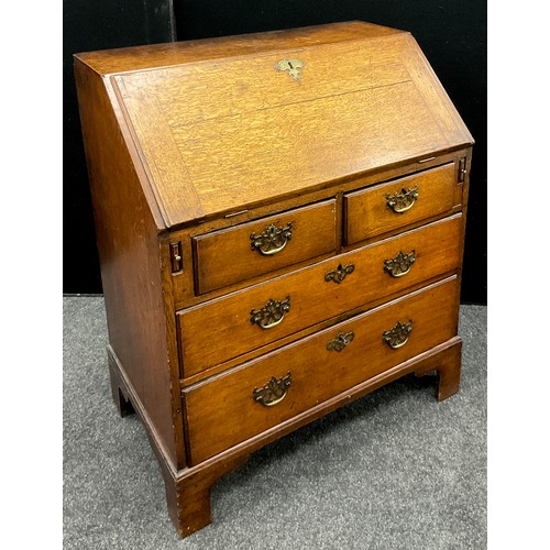 1123 - A George III oak bureau, of small proportions, fall door to top enclosing a fitted interior, with ce... 