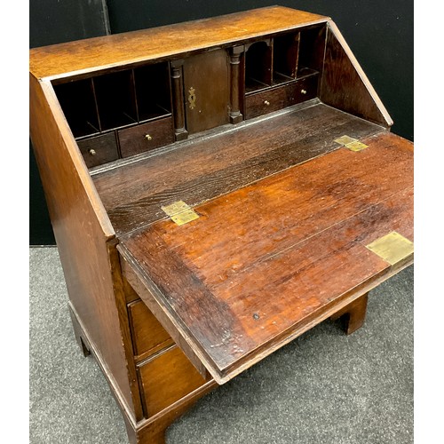 1123 - A George III oak bureau, of small proportions, fall door to top enclosing a fitted interior, with ce... 