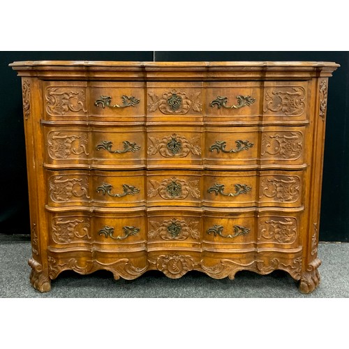 1238 - A Louis XV Revival carved oak commode chest, the shaped over-sailing top with a moulded frieze, over... 