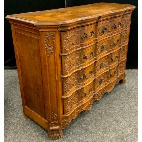 1238 - A Louis XV Revival carved oak commode chest, the shaped over-sailing top with a moulded frieze, over... 