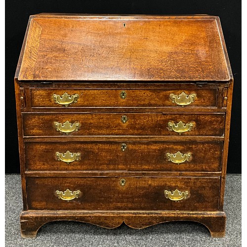 1122 - A George III oak bureau, fall front enclosing a fitted architectural interior, above four long gradu... 