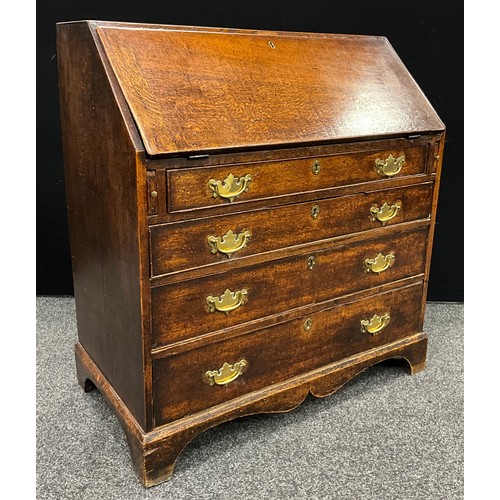 1122 - A George III oak bureau, fall front enclosing a fitted architectural interior, above four long gradu... 