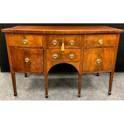 1112 - A George III mahogany bow front sideboard, oversailing top above an arrangement of drawers and a cup... 