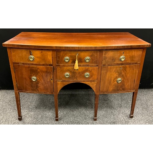 1112 - A George III mahogany bow front sideboard, oversailing top above an arrangement of drawers and a cup... 