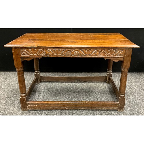 876 - An 18th century oak side table, oversailing planked top above a deep frieze carved meandering flower... 