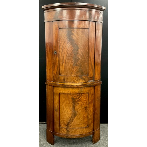 1045 - A George III mahogany bow-front floor-standing corner cupboard, moulded cornice, above two flame-mah... 