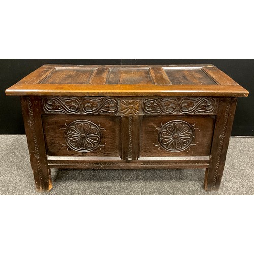 870 - An 18th century carved oak blanket chest or coffer, of small proportions, having a three-panelled hi... 