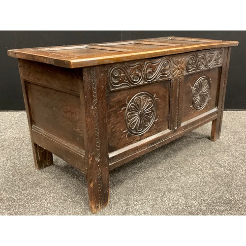 870 - An 18th century carved oak blanket chest or coffer, of small proportions, having a three-panelled hi... 