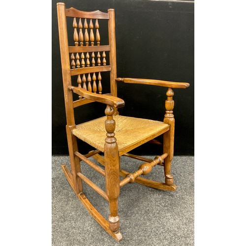 1048 - A Lancashire elm and ash ladder back rocking chair, rush seat, 114cm high x 62cm wide x 70cm deep.