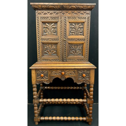 1237 - A Jacobean Revival oak hall cupboard, the cornice, doors, and drawer fronts carved in deep relief wi... 