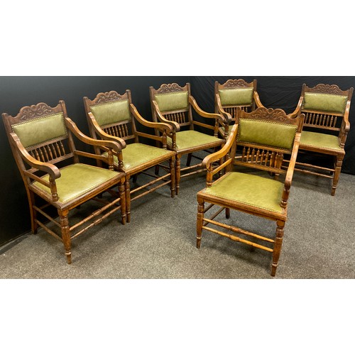 1240 - A set of six Edwardian Arts and Crafts oak armchairs, the shaped and carved top rail above a green l... 