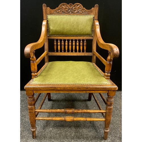 1240 - A set of six Edwardian Arts and Crafts oak armchairs, the shaped and carved top rail above a green l... 