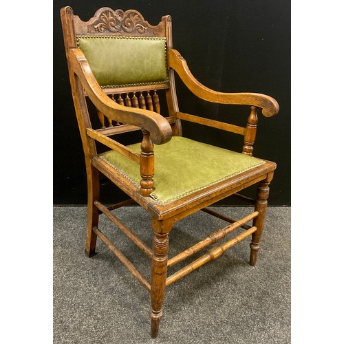 1240 - A set of six Edwardian Arts and Crafts oak armchairs, the shaped and carved top rail above a green l... 