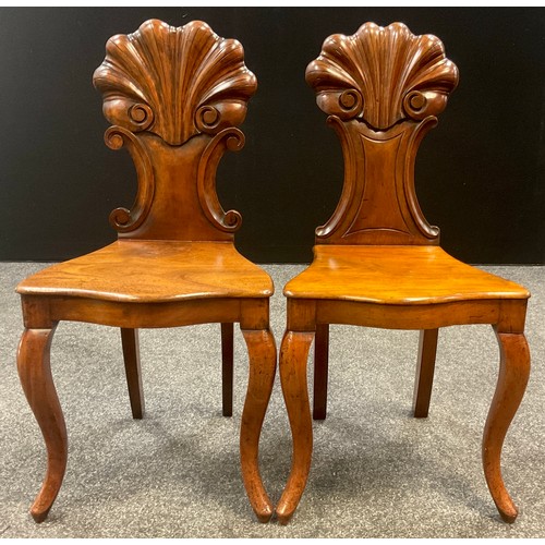 911 - A similar pair of 19th century walnut hall chairs, the carved scallop backs with c-scroll sides, ove... 