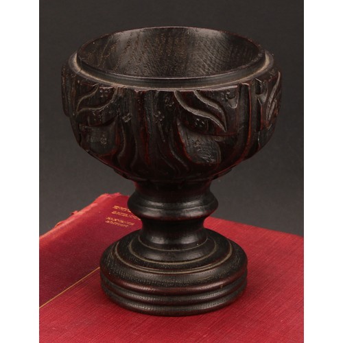 893 - A 19th century oak goblet or chalice, the bowl carved with acanthus, turned base, 14cm high,