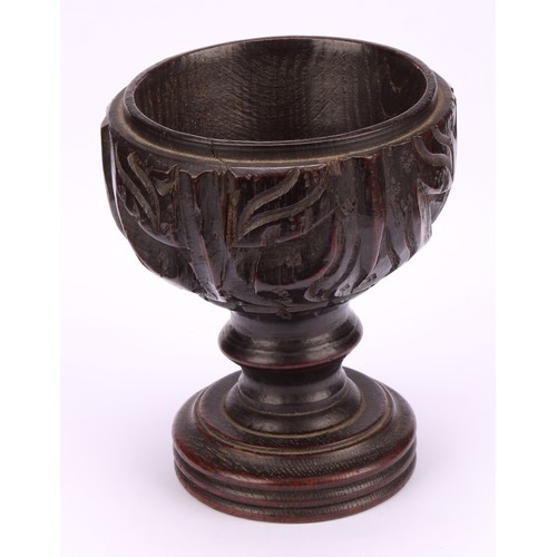 893 - A 19th century oak goblet or chalice, the bowl carved with acanthus, turned base, 14cm high,