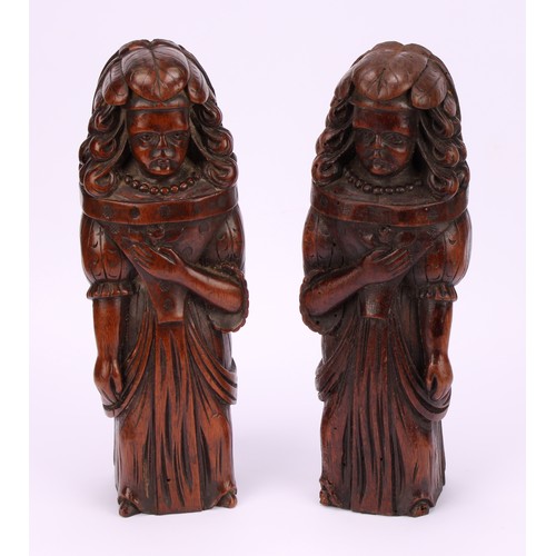 1242 - A pair of Continental walnut appliques, each carved as a lady of the court holding a flower to her b... 