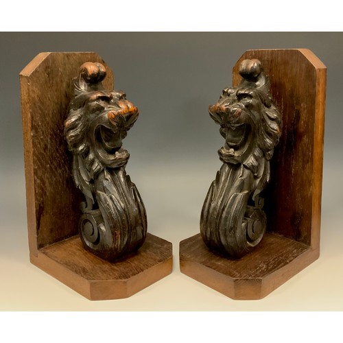 1246 - A pair of substantial oak country house book ends, each boldly carved with the head of lion terminat... 