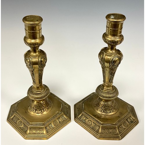 1226 - A pair of 18th century French brass table candlesticks, of seamed construction, cast with portrait r... 