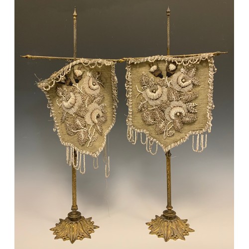 1227 - A pair of 19th century beadwork face screens, each with floral beaded shield in tones of grey, white... 