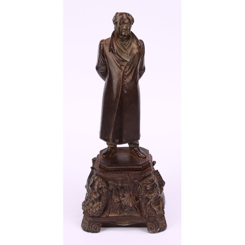 1251 - Continental school, 19th century, a bronzed iron figure of a figure standing wearing a long jacket a... 