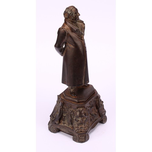 1251 - Continental school, 19th century, a bronzed iron figure of a figure standing wearing a long jacket a... 