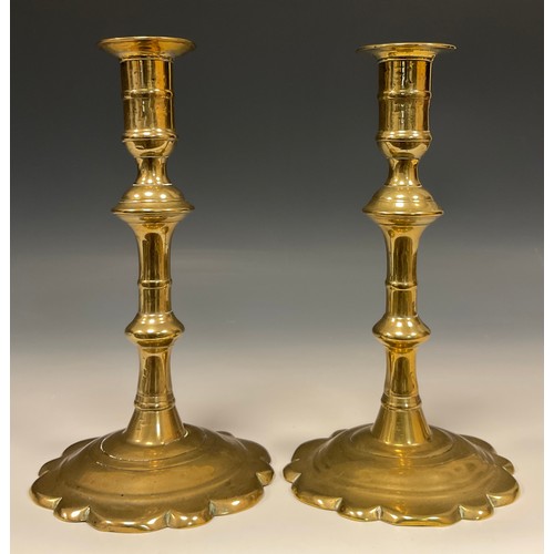 1245 - A pair of George II brass candlesticks, knopped pillar, petal bases, 19cm high, c.1740