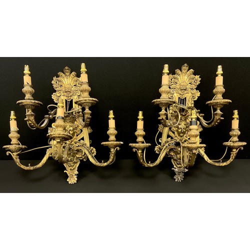 1023 - A pair of Baroque Renaissance style gilt metal wall lights, cast floral wall mounts with mask heads,... 